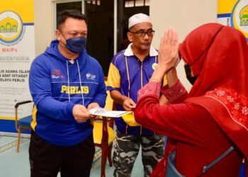TUANKU Syed Faizuddin Putra Jamalullail (kiri) berkenan menyerahkan sumbangan agihan zakat MAIPs kepada salah seorang penerima di Masjid Darul Salam, Padang Keria, Simpang Ampat, Kangar, Perlis. -UTUSAN