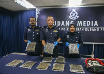 RODZI Abu Hassan (tengah) menunjukkan ketulan mampat dadah disyaki ganja seberat 10kg yang dianggarkan bernilai RM33,000 ketika sidang akhbar di IPD Kubang Pasu. -UTUSAN/ SHAHIR NOORDIN