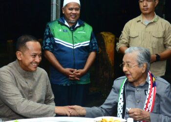 MAHATHIR Mohamad (kanan, duduk) bersalaman dengan calon Pas PRK Parlimen Kemaman, Datuk Seri Dr. Ahmad Samsuri Mokhtar pada Ceramah Perdana Grand Finale di Arena Square, Chukai di Kemaman, Terengganu. - UTUSAN/SHAIKH AHMAD RAZIF