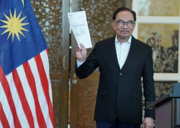 ANWAR Ibrahim menunjukkan senarai barisan Kabinet selepas sidang akhbar di Putrajaya. - UTUSAN/FAISOL MUSTAFA