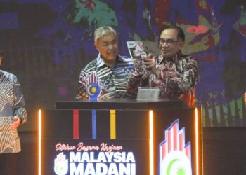 ANWAR Ibrahim melihat buku Setahun Bersama Kerajaan Madani yang dilancarkannya sambil disaksikan dua timbalannya, Ahmad Zahid Hamidi (dua dari kiri) dan Datuk Seri Fadilah Yusof (kanan) serta Menteri Komunikasi dan Digital, Fahmi Fadzil pada Majlis Penutup Sambutan Setahun bersama Kerajaan Malaysia Madani di pekarangan Stadium Nasional Bukit Jalil, hari ini. - UTUSAN/MUHAMAD IQBAL ROSLI