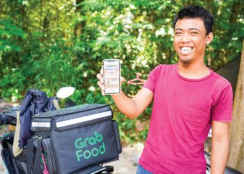 Penghantar makanan, Azrul Shahrizan Abdul Aziz, 24, adalah antara 6,5 juta rakyat yang sudah menebus e-kredit tunai eMadani sebanyak RM100. – UTUSAN/MOHD. FARIZWAN HASBULLAH