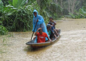 MASYARAKAT Orang Asli menaiki perahu untuk mengambil bantuan bakul makanan yang disediakan oleh pihak Jabatan Kebajikan Masyarakat Daerah Gua Musang di RPS Kuala Betis, Gua Musang, Kelantan. - UTUSAN/AIMUNI TUAN LAH