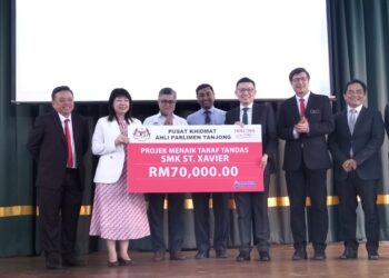 LIM Hui Ying (tengah) menyampaikan sumbangan bagi projek membaiki tandas di SMK St. Xavier, di George Town, Pulau Pinang, hari ini.