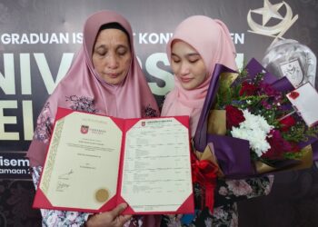 NUR HAZIRAH Yaacob (kiri) dan Rohayah Ahmad melihat Diploma Kejururawatan yang diterima Izah Suhailah Yaacob secara anumerta pada Majlis Konvokesyen Unimel Ke-25 di MITC, Ayer Keroh, Melaka. - UTUSAN/MUHAMMAD SHAHIZAM TAZALI