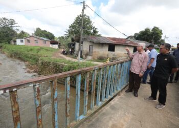 HASSAN ABDUL KARIM (kiri)  melihat Sungai Masai di Kampung Masjid, Masai, Johor Bahru yang kerap melimpah ekoran hujan lebat.