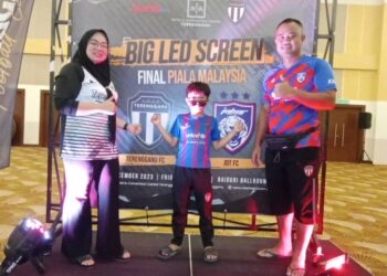 IKHWAN Rosli (kanan) bersama isteri dan anak bongsunya ketika tayangan siaran langsung final Piala Malaysia menerusi skrin besar di sebuah hotel di Kuala Nerus, malam ini. - UTUSAN/TENGKU DANISH BAHRI TENGKU YUSOFF