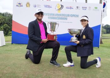 HARIZ Hezri dan Liu Yujie menjulang piala pusingan selepas muncul juara kategori lelaki dan wanita di Kejohanan Golf Amatur Terbuka Malaysia Edisi Ke-119 di Kelab Golf Tiara & Country, Melaka. - UTUSAN/AMRAN MULUP