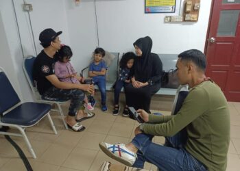 WANI (dua kanan) bersyukur apabila anaknya yang hilang selama kira-kira dua jam di Bazar Karat, Johor Bahru ditemukan selamat oleh pegawai polis.