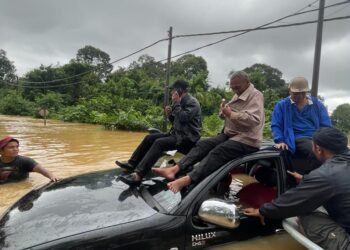 ABDULLAH A. Rahman (kanan) bersama Tengku Mahari Tengku Chik (kiri) dan dua lagi kenalan dibantu penduduk kampung selepas kenderaan dinaiki terkandas di Kampung Pengkalan Ajal, Ajil, Hulu Terengganu, hari ini. - UTUSAN/NOOR HAYATI MAMAT