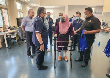HASBI Habibollah (kiri) bertanyakan sesuatu kepada seorang pesakit yang menjalani rawatan pemulihan di Pusat Rehabilitasi Perkeso Tun Abdul Razak, Ayer Keroh, Melaka. - UTUSAN/AMRAN MULUP