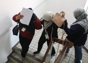 NUR Faraziela Mohamad (tengah) yang mengaku bersalah gagal mengemukakan borang nyata cukai pendapatan kepada LHDN meninggalkan Mahkamah Majistret Kuala Terengganu, hari ini. - UTUSAN/TENGKU DANISH BAHRI TENGKU YUSOFF