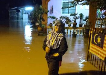 SEORANG penduduk berada di hadapan kediamannya yang dilimpahi air Sungai Siam di Felda Kota Gelanggi 1 di Jerantut, Pahang. - FOTO/IHSAN BIRO SOSIAL FELDA WILAYAH