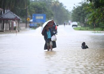 SEORANG penduduk meredah air dalam kejadian banjir di Hulu Terengganu. - UTUSAN/PUQTRA HAIRRY ROSLI