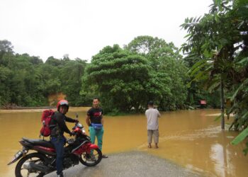 ROSMI Rosli terkandas selepas air Sungai Betis melimpahi jambatan di RPS Kuala Betis, Gua Musang, Kelantan hari ini.UTUSAN/AIMUNI TUAN LAH