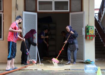 GURU dan kakitangan sekolah membersihkan kelas selepas dilanda banjir di Sekolah Kebangsaan Tengku Ampuan Intan, Hulu Terengganu. - UTUSAN/PUQTRA HAIRRY ROSLI