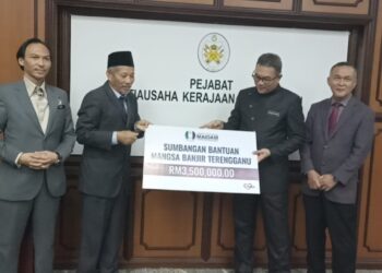 SHAIKH Harun Shaikh Ismail (dua dari kiri) menyampaikan bantuan sumbangan banjir sebanyak RM3.5 juta daripada MAIDAM kepada Tengku Farok Hussin Tengku Abd Jalil di Kuala Terengganu, hari ini. - UTUSAN/KAMALIZA KAMARUDDIN