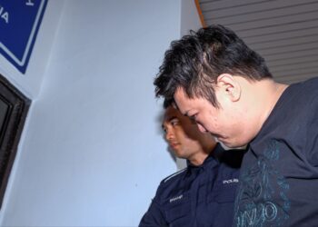 SEORANG lelaki diiringi anggota polis di atas pertuduhan mengedar dadah jenis methamphetamine berat kasar berjumlah 10,392.20 gram ketika pertuduhan dibacakan di Kompleks Makhamah Ayer Keroh, Melaka. -UTUSAN/SYAFEEQ AHMAD