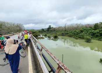 ORANG ramai tidak melepaskan peluang unutuk melihat fenomena air banjir bewarna hijau di Kampung Kuala Hau, Machang, Kelantan hari ini-UTUSAN/YATIMIN ABDULLAH