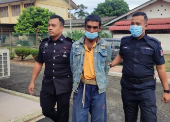 RAJARAM Sahani (tengah) dikawal anggota polis yang membawanya ke mahkamah bagi berdepan pertuduhan cuba menculik kanak-kanak di Mahkamah Gurun.
