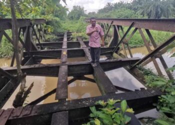 NIZA Harun menunjukkan jambatan kereta api lama di Kampung Sungai Sidin yang terbiar di Teluk Intan. 
– UTUSAN/AIN SAFRE BIDIN