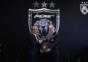 Hector Bidoglio (kiri) yang akan membimbing JDT bertukar dokumen dengan Alistair Edwards, semalam. - IHSAN JOHOR SOUTHERN TIGERS