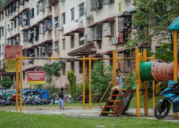 KANAK-KANAK bermain di taman permainan yang terdapat blok R Apartmen Idaman, Damansara Damai di  di sini, semalam.-UTUSAN/FARIZ RUSADIO