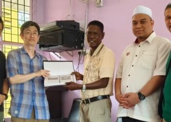 DR. NABUTA Toshihiro (dua kiri) menyampaikan hasil kajian kehidupan Orang Asli Kensiu yang dilakukan oleh Nagata kepada Razali Kulim (tengah) di Dewan Orang Asli, Kampung Ulu Legong, Baling. - UTUSAN/NORLIA RAMLI