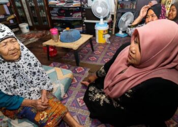 SITI Hawa Hussin (kiri) berbual dengan penduduk yang turut menziarahnya di Kampung Kajang Sebidang, Tumpat, Kelantan. - UTUSAN/ROHANA MOHD.NAWI