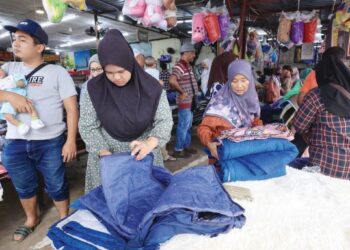 ORANG ramai menyerbu premis yang mengadakan jualan lelong selepas Rantau Panjang, Kelantan dilanda banjir minggu. - UTUSAN/KAMARUL BISMI KAMARUZAMAN