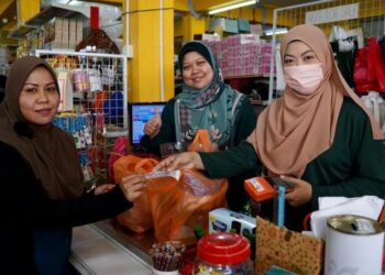 SEORANG asnaf MAINS mendapatkan barangan bantuan keperluan asas secara tanpa tunai dari sebuah kedai panel di Ampangan, Seremban, baru-baru ini. - IHSAN MAINS