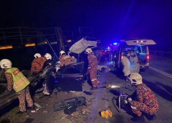 ANGGOTA bomba sedang mengeluarkan tiga mangsa yang maut daripada kereta Perodua Alza yang remuk dalam kemalangan jalan raya di Kilometer 17, Jalan Lipis-Benta di Lipis, Pahang.