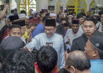 ANWAR Ibrahim menyantuni jemaah selepas menunaikan solat Jumaat di Masjid Kota Damansara hari ini. - UTUSAN/FARIZ RUSADIO