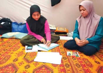 HASMIDA Kamarudin (kiri) ditemani ibunya, Norihah Jusof ketika mengulangkaji di PPS Gual To’ Deh, Rantau Panjang, Kelantan.
– UTUSAN/ROHANA ISMAIL