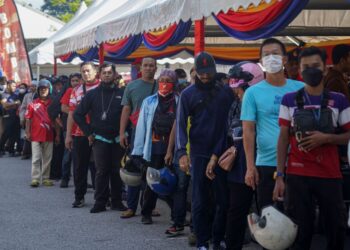 ORANG ramai beratur menunggu giliran untuk menukar topi keledar yang diagihkan secara percuma kepada 1,000 pengunjung terawal sempena Program Setahun Bersama Kerajaan MADANI di pekarangan Stadium Nasional Bukit Jalil (SNBJ) di sini, semalam.-UTUSAN/FARIZ RUSADIO