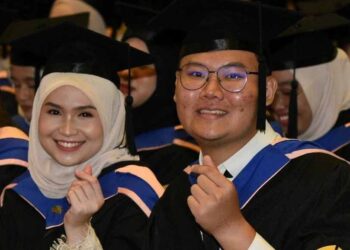 Ng (kanan) dan Nurhamizah selepas menerima skrol pada sidang 3, Majlis
Konvokeysen UMS kali ke-25