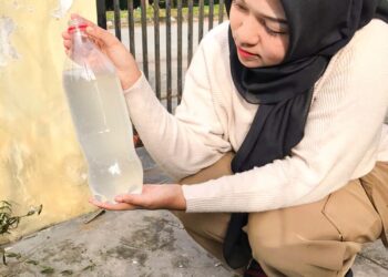 NORANISSA Izzati Muhamad  Nor menunjukkan air paip yang keruh dan berbuih di Taman Desa Mekar,  Parit Buntar. - UTUSAN/WAT KAMAL ABAS
