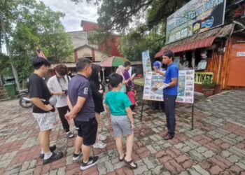 PELANCONG diberi penerangan sebelum melawat Pulau Bangau di Teluk Intan. - UTUSAN/WAT KAMAL ABAS