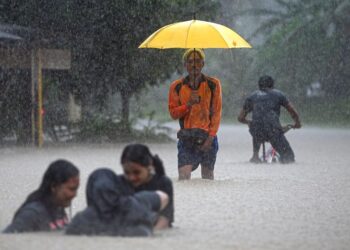 PENDUDUK meredah air banjir di Kampung Shukor, Dungun Terengganu. - UTUSAN/PUQTRA HAIRY