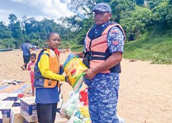 ROSLAN Abu Kassim (kanan) menyampaikan bantuan barang keperluan dapur sumbangan Sahabat Jariah Malaysia/Yayasan Food Bank Malaysia dan Pasar Raya Econsave Jerantut di tepi Sungai Tembeling, Kuala Tahan, Jerantut baru-baru ini. – UTUSAN/HARIS FADILAH AHMAD