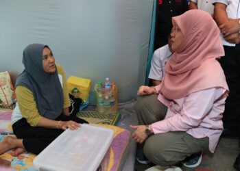FADHLINA Sidek (kanan) beramah mesra dengan mangsa banjir yang berlindung di pusat pemindahan sementara (PPS) Sekolah Kebangsaan (SK) Gual Tinggi, Rantau Panjang, Kelantan-UTUSAN/KAMARUL BISMI KAMARUZAMAN.