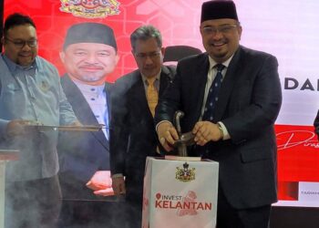 MOHAMED Fadzli Hassan (kanan) menyempurnakan gimik pelancaran RKK Bandar Baru Tunjong dan Kit Invest Kelantan di Kompleks Kota Darulnaim, Kota Bharu, Kelantan hari ini. UTUSAN/MUSTAQIM MOHAMED