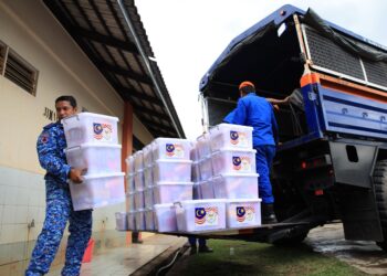 ANGGOTA APM menyusun barang bantuan untuk diagihkan kepada mangsa banjir di PPS SK Gual Tinggi, Rantau Panjang, Kelantan-UTUSAN/KAMARUL BISMI KAMARUZAMAN.