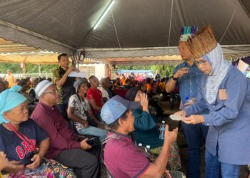 SAPIAH Mohd. Nor (kanan) beramah mesra dengan penduduk Orang Asli di Rancangan Pengumpulan Semula (RPS) Kuala Betis, Gua Musang, Kelantan, semalam.UTUSAN/AIMUNI TUAN LAH.