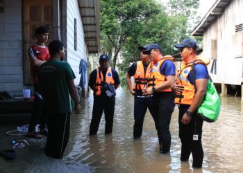 ANGGOTA polis turun padang memantau situasi banjir di Kampung Serongga, Pasir Mas, Kelantan-UTUSAN/KAMARUL BISMI KAMARUZAMAN.