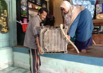 MAZNAH Mat Yasin dan suami, Mansor Ali mengalihkan barangan di  tempat lebih tinggi dalam rumah mereka untuk persediaan awal hadapi banjir di Kampung Kemat, Hulu Terengganu, semalam. 
– UTUSAN/NOOR HAYATI MAMAT