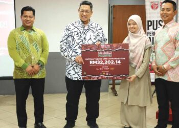 Dr. Ahmad Farhan Mohd Sadullah (dua kiri) menyerahkan kutipan Tabung UPM X MyFundAction kepada Atirah Mohd Affandi. Di Serdang baru-baru ini.