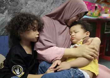 NORHIDAYAH Zulkarnain mencium anak istimewanya, Mohamad Abdullah ketika ditemui di rumahnya di Taman Semarak 2, Nilai, Seremban. – UTUSAN/NUR SHARIEZA ISMAIL