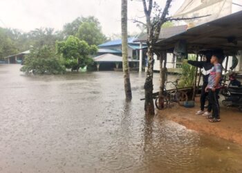 DUA penduduk melihat kawasan rumah mereka yang masih ditenggelami air di Kampung Tersang, Rantau Panjang, Kelantan-UTUSAN/ROSMIZAN RESDI