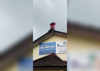 SUSPEK berusia 31 tahun berada di atas bumbung sebuah rumah di Taman Pertam Jaya, Melaka.
